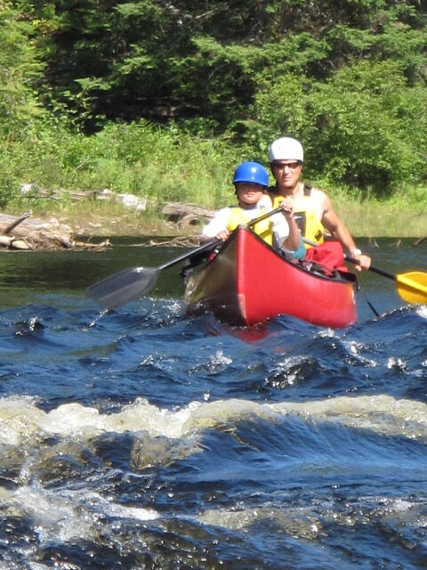 Father and son paddling in a canoe